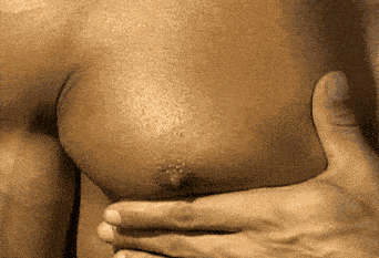 a close up of a person 's chest with a hand holding it