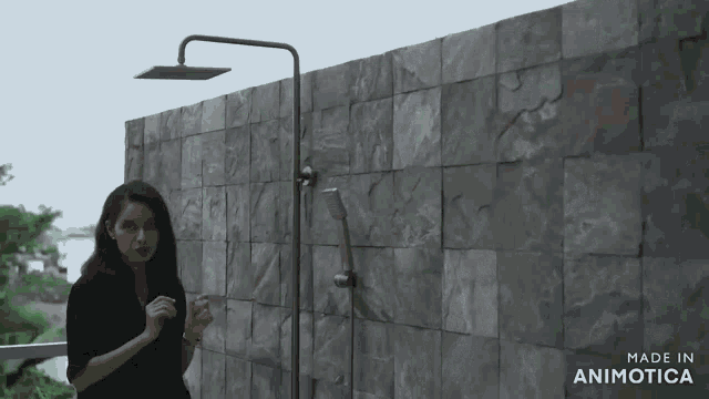 a woman is standing in front of a wall with the words made in animotica on it