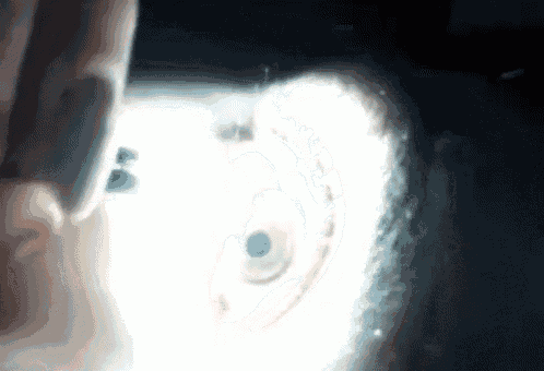 a close up of a person 's hand holding a pencil in a dark room .