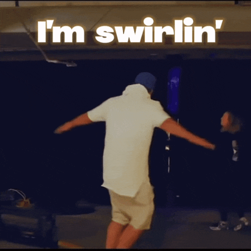 a man is dancing in front of a sign that says " i 'm swirlin "