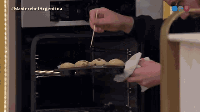 a man is taking a muffin out of the oven with a toothpick and the words masterchef argentina visible in the corner
