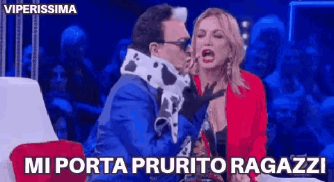 a man in a blue suit and a woman in a red jacket are fighting each other .