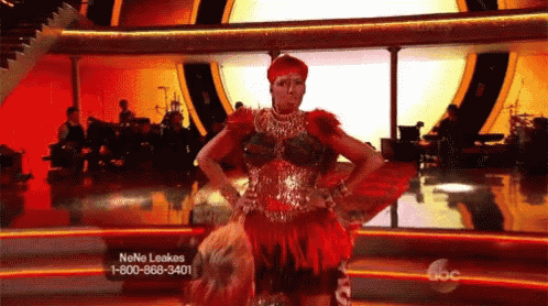 a woman in a red dress is dancing on a stage with a phone number for neno leakes