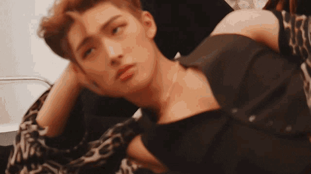 a close up of a man laying down with his hand in his hair