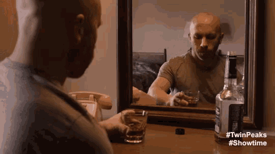 a man is drinking a glass of whiskey in front of a mirror with #twinpeaks #showtime written below him
