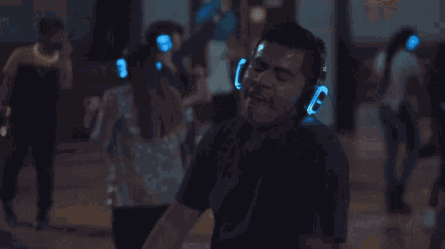 a man wearing headphones is dancing in front of a crowd