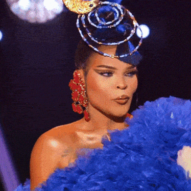a woman wearing a blue feathered dress and a blue hat