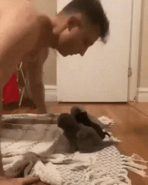 a man without a shirt is standing on a rug next to a door .