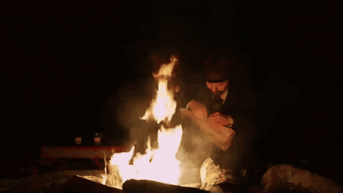 a man in a suit and hat is cutting a piece of wood