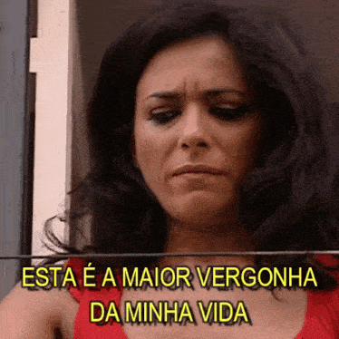a woman in a red top is crying with the words esta e a maior vergonha da minha vida above her