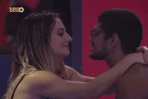 a man and a woman are hugging each other in a room .