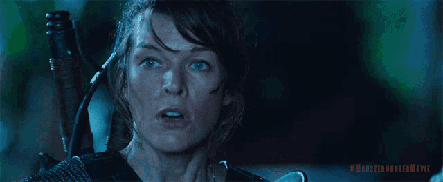 a close up of a woman holding a sword with the hashtag #monsterhuntermovie on the bottom