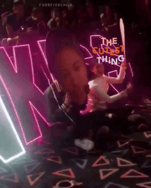 a person holding a sign that says " the cutest thing "