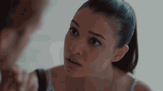 a woman in a ponytail is looking at a man