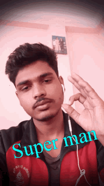 a man wearing ear buds and a jacket that says super man on it