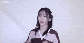 a girl wearing glasses and a striped sweater is covering her ears .
