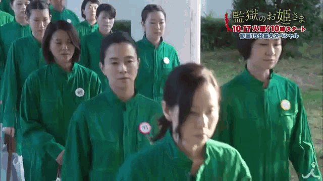 a group of women in green uniforms are standing in a line with a sign that says 10 17