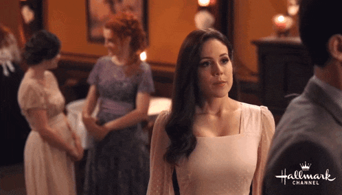 a woman in a white dress is standing in front of a man in a hallmark channel ad