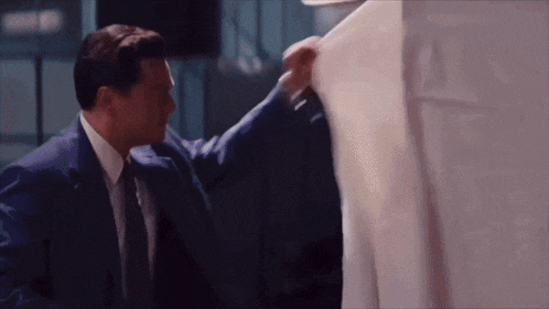 a man in a suit and tie is holding a piece of paper in his hand