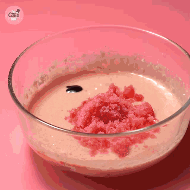 a person is mixing something in a bowl that says cake on the top