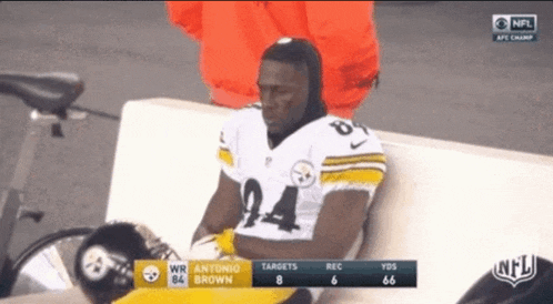 antonio brown sits on a bench during a game