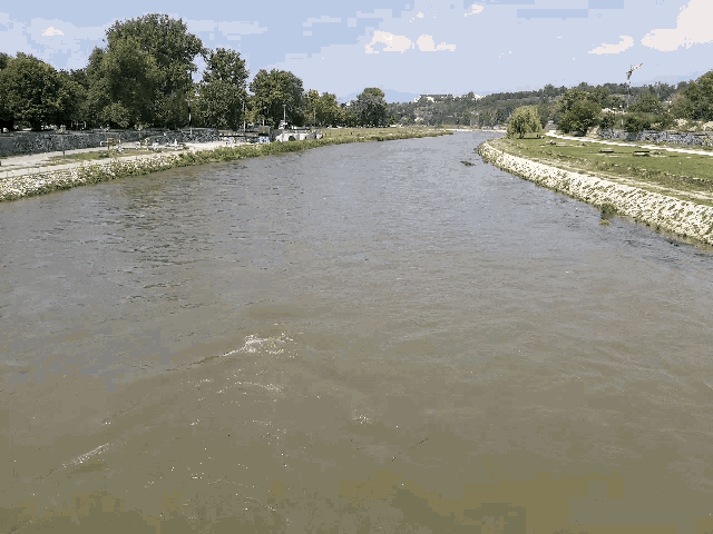 a river runs through a park with trees on the shore