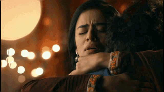 a woman with her eyes closed is being held by a man