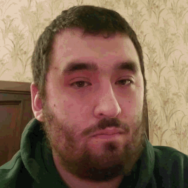 a man with a beard is looking at the camera