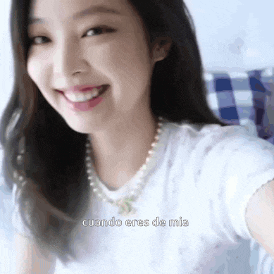a close up of a woman taking a selfie with the words `` cuando eres de mia '' in the corner .