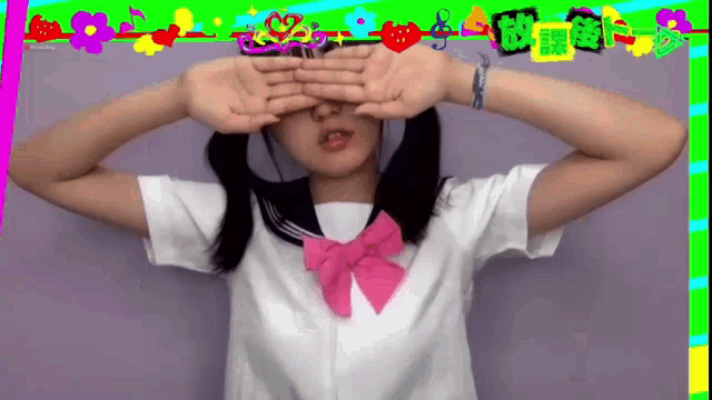 a girl covering her eyes with her hands in front of a purple background