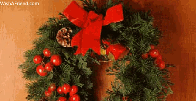 a christmas wreath with berries and a red bow
