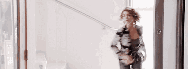 a woman is walking down stairs in a doorway .