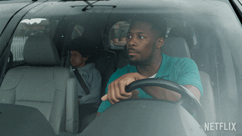 a man is driving a car with netflix written on the side