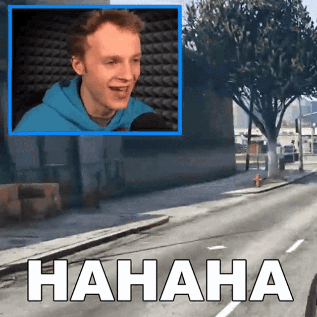 a man in a blue hoodie is laughing in front of a sign that says ' haha '