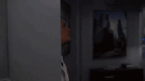 a woman in a white coat is reaching into a shelf