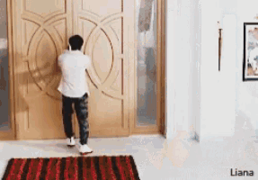 a man is standing in front of a large wooden door