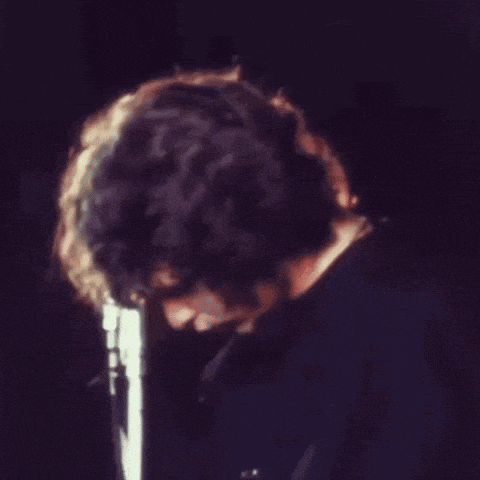 a man singing into a microphone with his hand on his mouth