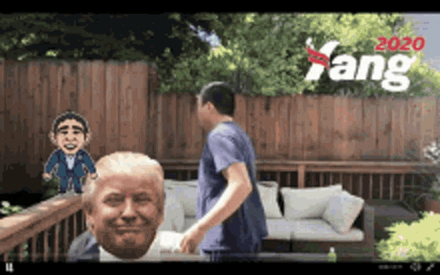a man is standing in front of a donald trump statue