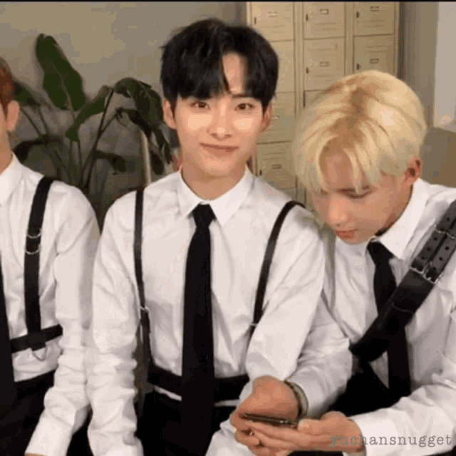 a group of young men wearing suspenders and ties are sitting together