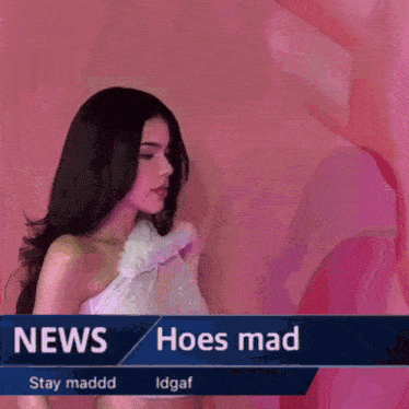 a woman in a white dress stands in front of a pink wall with the words news hoes mad on it