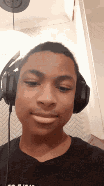 a young man wearing headphones and a black shirt that says ' to fight ' on it
