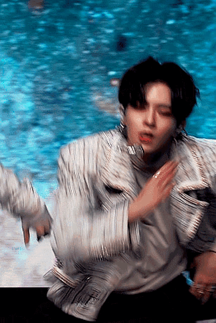 a blurry picture of a man dancing in front of a pool of water