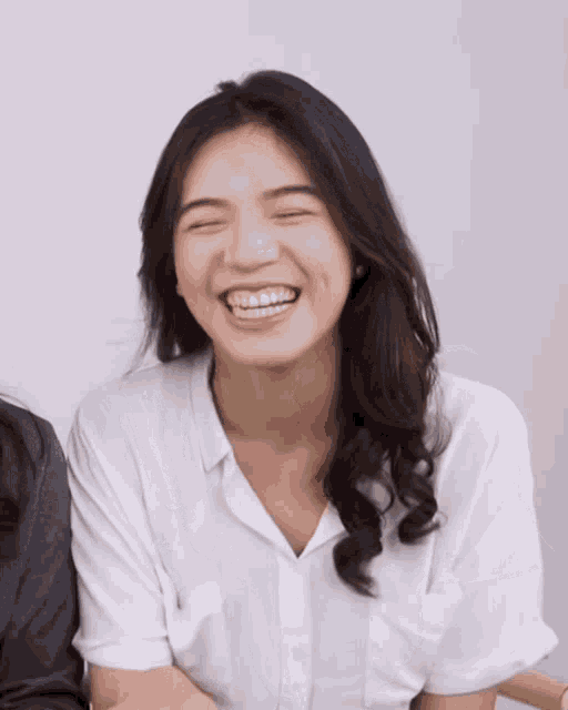 a woman is smiling with her eyes closed