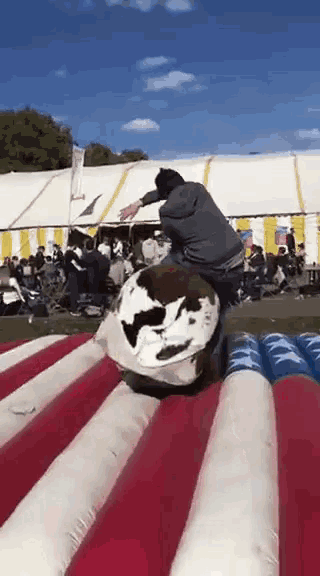 a man riding a bull on a red white and blue inflatable