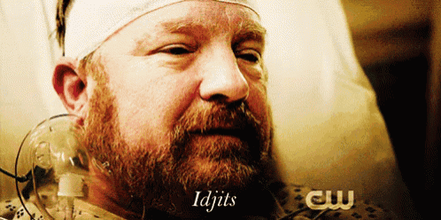 a man with a beard is laying in a hospital bed with the words " idjits " on the bottom