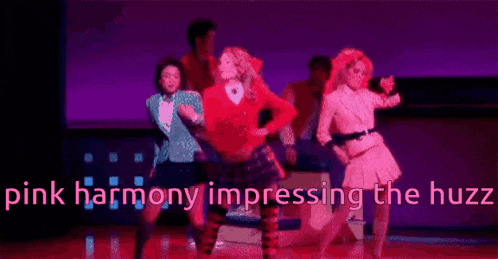 a group of people are dancing on a stage with the words `` pink harmony impressing the huzz '' in the background .