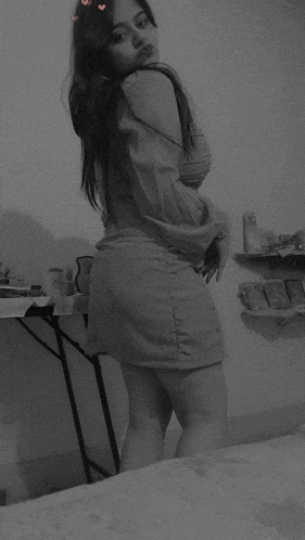 a black and white photo of a woman in a short skirt