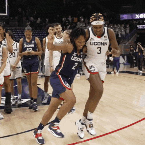 two uconn basketball players are dancing on a court