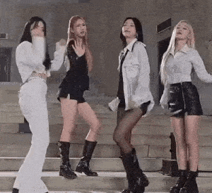 four women are standing next to each other on a set of stairs .