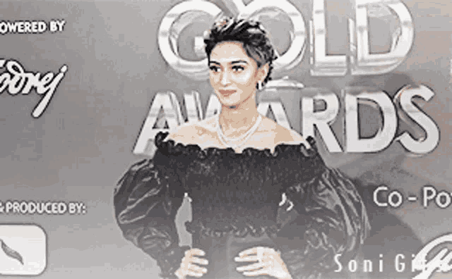 a woman is standing in front of a sign that says gold awards